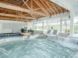 A hot tub with seating area and large windows at Chapel Green Studio 2 in Polgooth