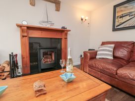 A living room with a fireplace and a sofa at Fairhaven Cottage in Ugthorpe near Runswick Bay