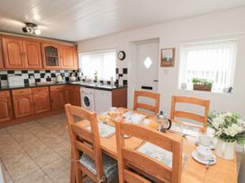 A kitchen with wooden cabinets and dining table at Fairhaven Cottage Ugthorpe near Runswick Bay