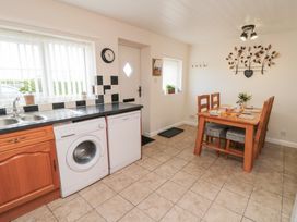 A kitchen with a washing machine and table at Fairhaven Cottage in Ugthorpe near Runswick Bay