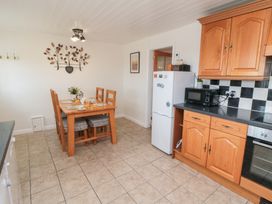 A kitchen featuring a dining table with chairs at Fairhaven Cottage in Ugthorpe near Runswick Bay