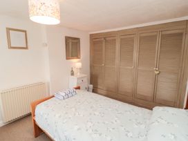 A bedroom with a bed and wardrobe at Fairhaven Cottage Ugthorpe near Runswick Bay