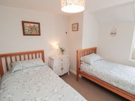 A bedroom with two beds and a nightstand at Fairhaven Cottage near Runswick Bay
