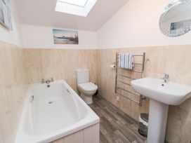 A bathroom with a bathtub, toilet, and sink at Fairhaven Cottage in Ugthorpe near Runswick Bay