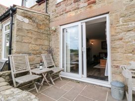 An outdoor seating area with chairs and a table at Fairhaven Cottage Ugthorpe near Runswick Bay