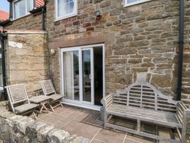 An outdoor seating area with chairs and a bench at Fairhaven Cottage in Ugthorpe near Runswick Bay