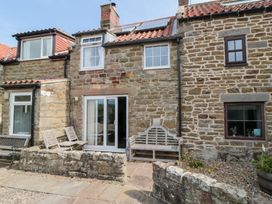 A garden with seating and stone walls at Fairhaven Cottage in Ugthorpe near Runswick Bay