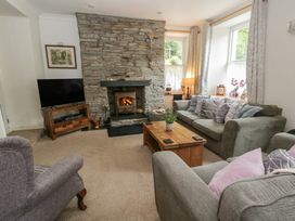 A living room with a stone fireplace and sofas at Teifi House in Cilgerran near Cardigan