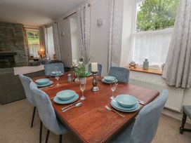 A dining room with a wooden table set for a meal at Teifi House in Cilgerran near Cardigan