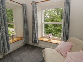 A sitting room with windows and a sofa at Teifi House in Cilgerran near Cardigan