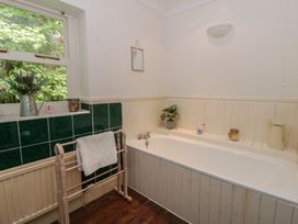 A bathroom with a bathtub and plant at Teifi House in Cilgerran near Cardigan