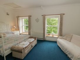 A bedroom with a bed and a sofa at Teifi House in Cilgerran near Cardigan