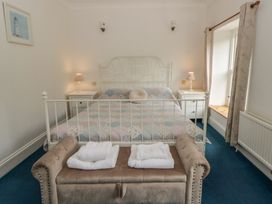 A bedroom with a bed and bench at Teifi House in Cilgerran near Cardigan