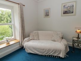 A living room with a sofa, lamp, and window at Teifi House in Cilgerran near Cardigan