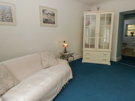 A living room with a sofa and a display cabinet at Teifi House in Cilgerran near Cardigan