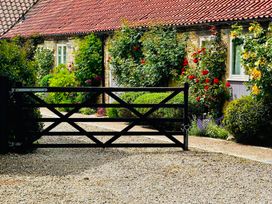 A garden with a gate and flowers at Grouse Cottage near Low Hagg Farm