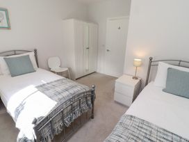 A bedroom with two beds and a wardrobe at The Haven in Embleton