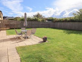 A garden with a table and chairs under an umbrella at The Haven in Embleton