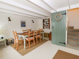 A dining room with a table and chairs at Fern Cottage in Aberporth