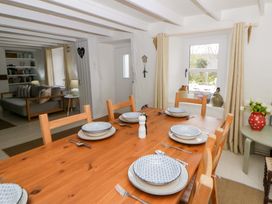 A dining room with a table set for dinner at Fern Cottage, Aberporth