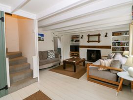 A living room with a staircase and seating area at Fern Cottage in Aberporth