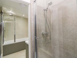 A bathroom with a shower and bathtub at Fern Cottage Aberporth