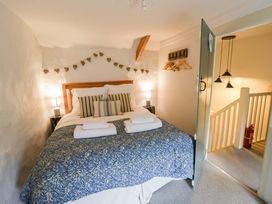 A bedroom with a bed and bedside lamp at Fern Cottage in Aberporth