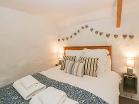 A bedroom with a bed and bedside lamps at Fern Cottage in Aberporth