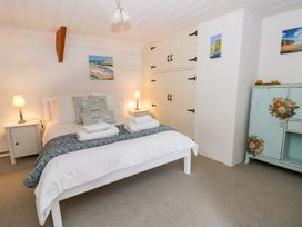 A bedroom with a bed and nightstands at Fern Cottage in Aberporth