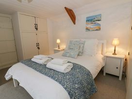 A bedroom with a bed and bedside tables at Fern Cottage in Aberporth