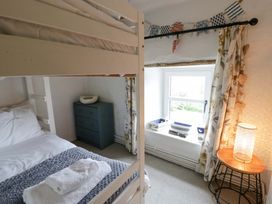 A bedroom with a bunk bed and a lamp at Fern Cottage in Aberporth