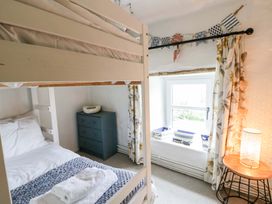 A bedroom with a bunk bed and a double bed at Fern Cottage in Aberporth