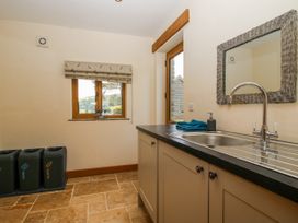 A utility room with a sink and recycling bins at The Hayloft in Bleddfa near Knighton