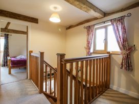 A landing with wooden stairs and a window at The Hayloft in Bleddfa near Knighton