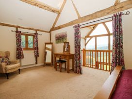 A bedroom with an armchair and dressing table at The Hayloft in Bleddfa near Knighton