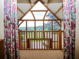 A balcony with wooden railing and curtains at The Hayloft in Bleddfa near Knighton
