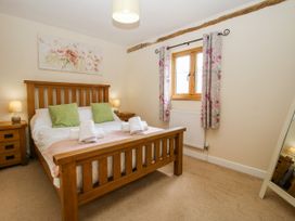 A bedroom with a wooden bed and floral decor at The Hayloft in Bleddfa near Knighton