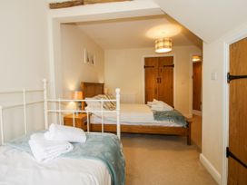 A bedroom with two beds and wooden furniture at The Hayloft in Bleddfa near Knighton