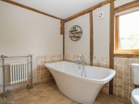 A bathroom with a bathtub, toilet and radiator at The Hayloft Bleddfa near Knighton