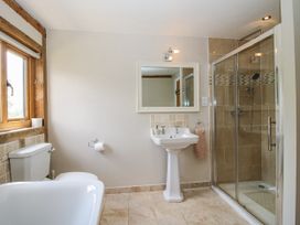 A bathroom with a bathtub, toilet, sink, and shower at The Hayloft in Bleddfa near Knighton