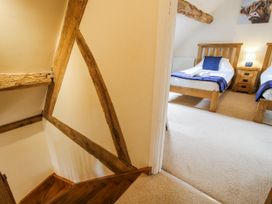 A bedroom with two beds and wooden beams at The Hayloft Bleddfa near Knighton