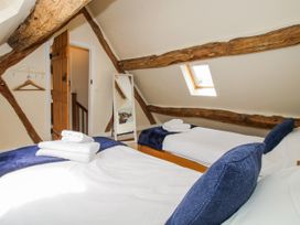 A bedroom with two beds and a mirror at The Hayloft in Bleddfa near Knighton