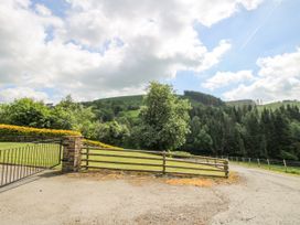 An outdoor scene with a gate and trees at The Hayloft in Bleddfa near Knighton