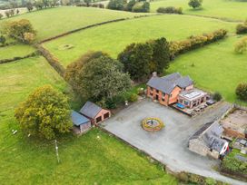 An outdoor area with a house, parking area and garden at Ty Newydd in Llangadfan