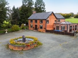 A house with a fountain and flower beds at Ty Newydd in Llangadfan