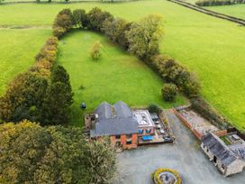An outdoor view of a house with a garden and pool at Ty Newydd in Llangadfan