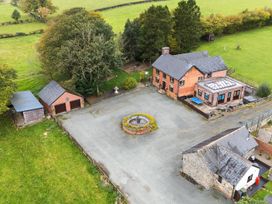 An outdoor view of a house with a garden and parking area at Ty Newydd, Llangadfan