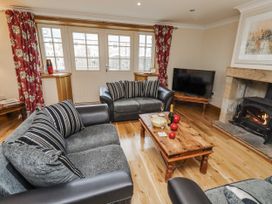 A living room with a sofa and fireplace at High Hemmel House in Embleton