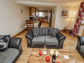 A living room with a coffee table and kitchen in High Hemmel House Embleton