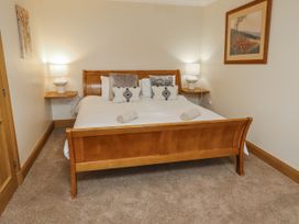 A bedroom with a bed and bedside lamps at High Hemmel House in Embleton